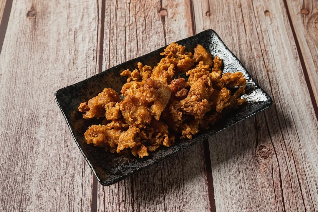 A breathtaking close-up photo of a golden-brown Japanese-fried pork cutlet, crispy exterior and juicy interior, drizzled with savory sauce.