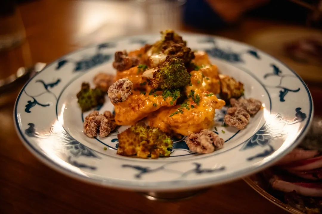 A close-up photo of a golden-brown Japanese fried pork cutlet, crispy exterior with juicy meat inside, drizzled with savory sauce on a traditional plate.