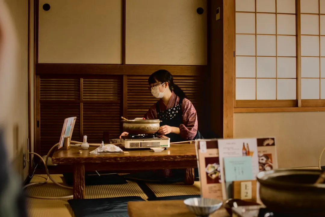 A Japanese man happily bites into a golden-brown crispy pork cutlet, while admiring the serene beauty of a traditional Japanese garden setting