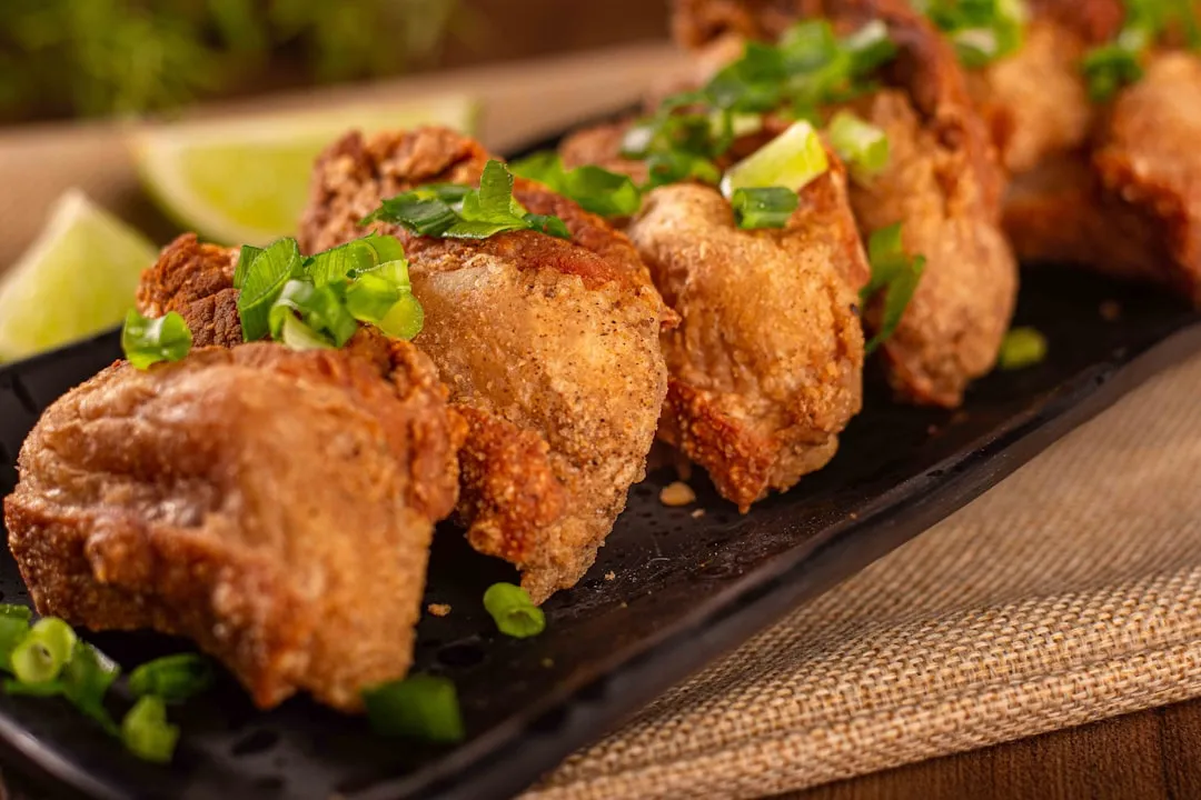 A mesmerizing close-up of a golden-brown crispy pork cutlet, drizzled with sweet sauce and served on a traditional Japanese plate with delicate bamboo chopsticks. The vibrant green background emphasizes the richness of the dish.