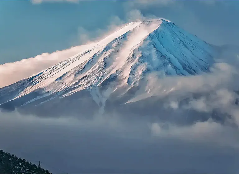 Iconic Mount Fuji winter landscape: A majestic telephoto shot of the snow-capped peak from Lake Kawaguchiko.