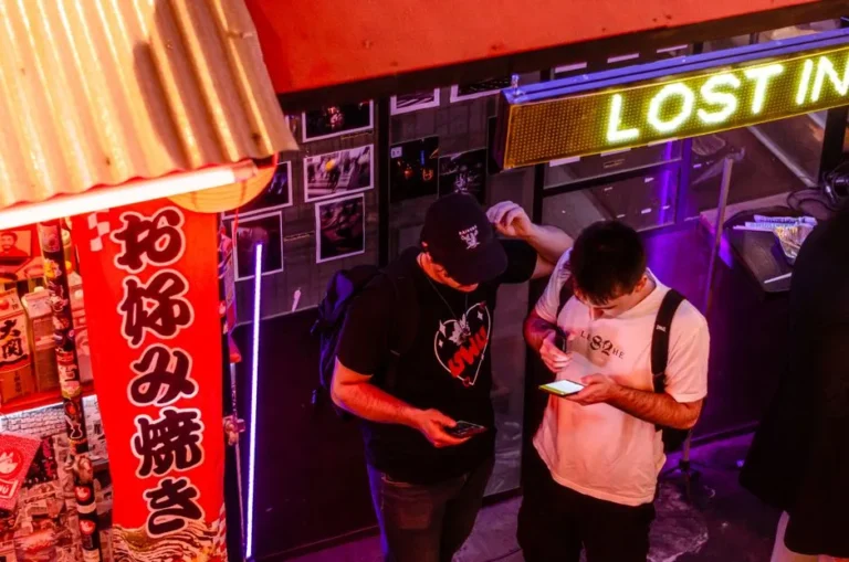 Vibrant city lights illuminate foreign tourists effortlessly swiping their Suica cards at a modern station entrance, capturing the seamless transportation experience in Japan.